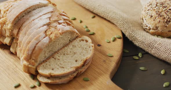 Video of bread on chopping wooden board on wooden worktop