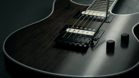Details of six-string electric guitar. Pickups, strings, floyd-rose, fretboard.
