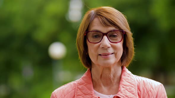 Portrait of Happy Senior Woman in Glasses at Park