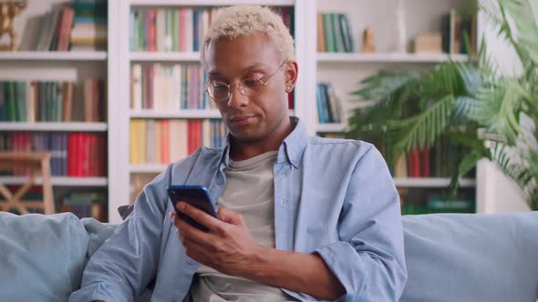 Young Perplexed African American Man Learns Bad News in Phone Reading Email