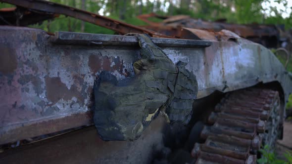 Burnt Down Military Body Armor Hanging on Destroyed Tank Outdoors