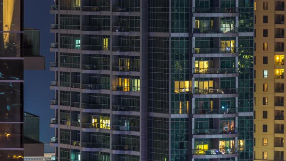 Glowing Windows in Multistory Modern Glass and Metal Residential Building Light Up at Night