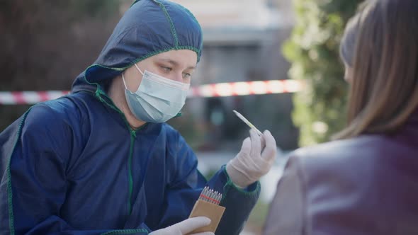 Portrait of Confident Concentrated Woman in Forensics Uniform and Face Mask Talking Showing Ampoules