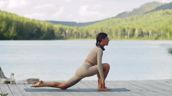 Fit Woman Practicing Yoga on Lake Pier