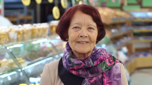 Portrait of a Cute Retired Woman in a Grocery Store in the Bread Department