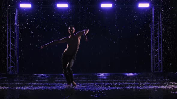 Contemporary Ballet Man Performs Elements of Modern Choreography Standing on Surface Water in Rain