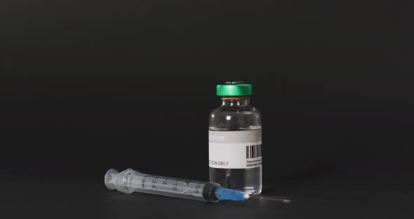 Video of close up of vaccine vial on black background