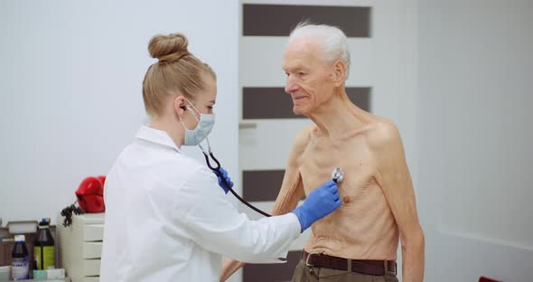 Female Doctor Examine Elderly Man with Stethoscope alt