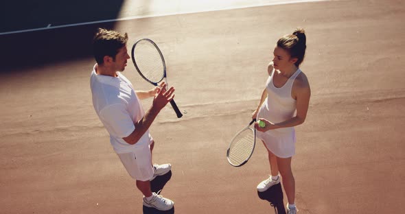 Woman and man playing tennis on a sunny day