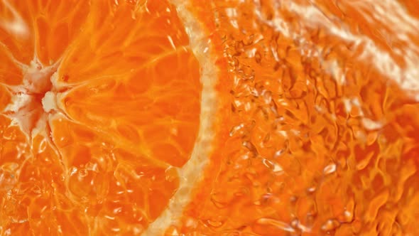 Super Slow Motion Shot of Splashing Water From Rotating Tangerine Slice at 1000Fps.