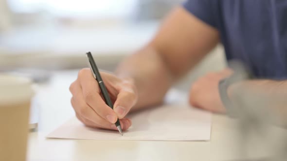 Close Up of Male Hands Writing on Paper