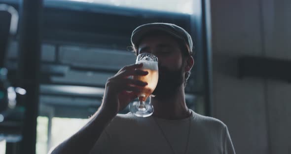 Man relaxing afterwork and drinking a fresh crafted beer in a modern bar