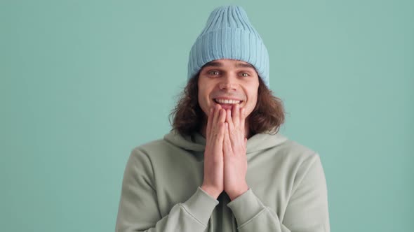 Cute man in blue hat rejoicing