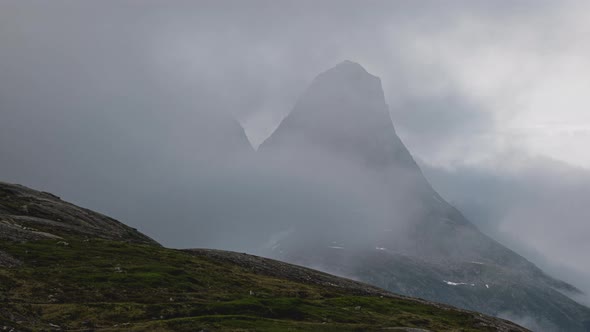 Timelapse Of White Fluffy Clouds Covering Rocky Mountain In Norway. - zoom out