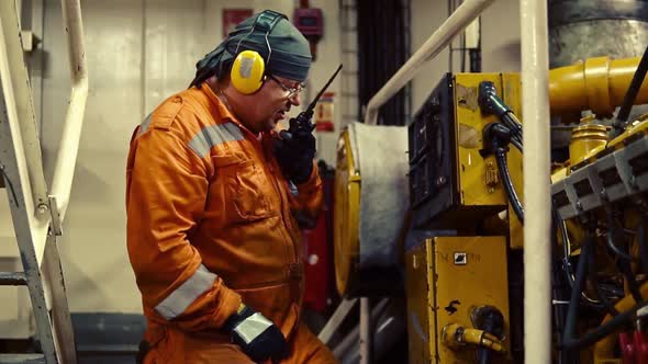 Marine Engineer Inspecting Ship's Engine in Engine Control Room