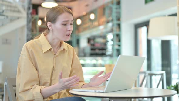 Young Woman Upset By Loss on Laptop in Cafe 