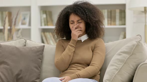 Young African Woman Sitting and Crying on Sofa