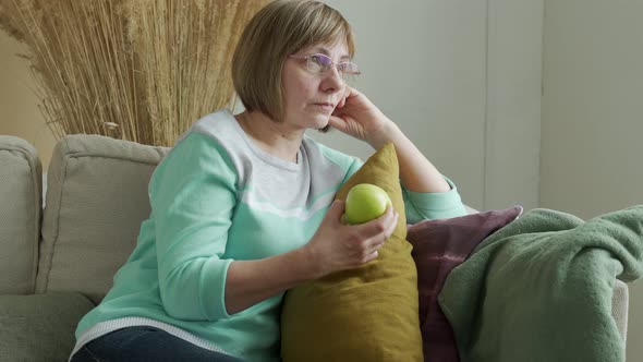 Elderly Woman Holding a Green Apple in Her Hands Healthy Diet Concept