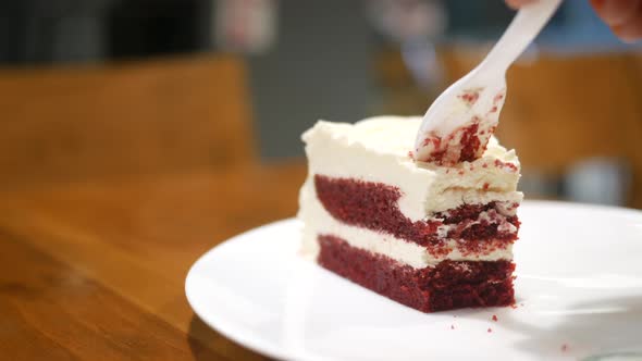 Cutting Red Velvet Cake with Plastic Spoon at Cafe