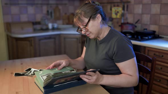 Middle aged woman looking at family photo album. Nostalgia, happines