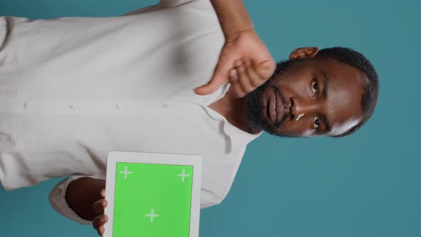 Vertical Video Young Freelancer Holding Horizontal Green Screen in Studio