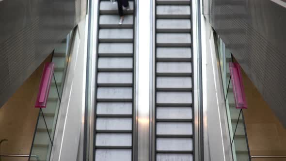 Woman hurrying down escalator