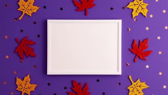 Stop motion animation of yellow and red felt autumn leaves star shapes and picture frame on purple