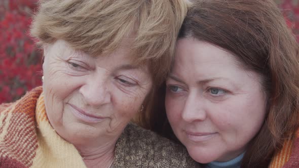 Portrait of an Elderly Woman with Her Daughter Against the Backdrop of an Autumn Landscape