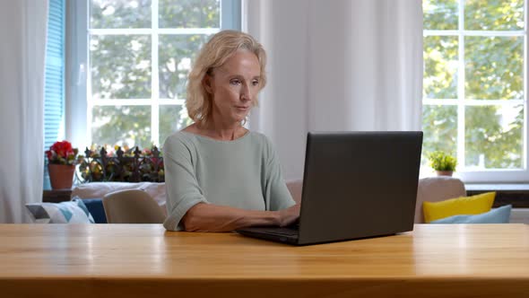 Senior Woman with Laptop Working at Home Office