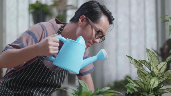 Close Up Of Asian Man Holding Watering Pot To Water The Plants At Home