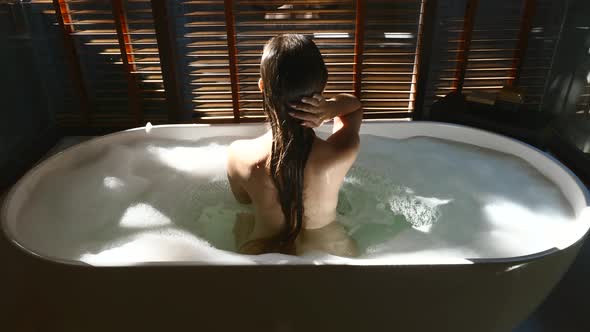 Sexy Woman Taking Romantic Bathtub with Bubbles at Home Relaxing and Spa