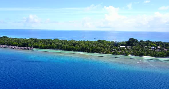 Natural above island view of a white paradise beach and aqua blue ocean background in colourful 4K