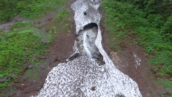 Stream Flowing Under the Snow Mass