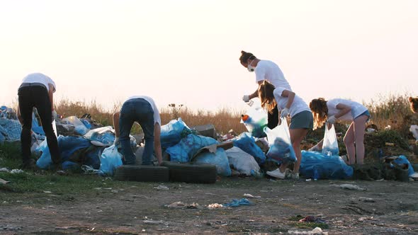 Group of Eco Volunteers Cleaning Up Area of Dump Near the Road During Sunset Slow Motion