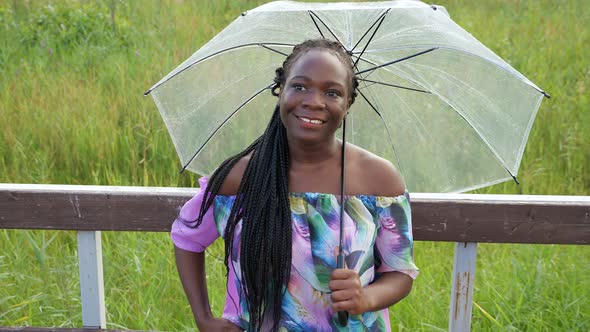 Stylish African-American Lady with Umbrella Near Handrail