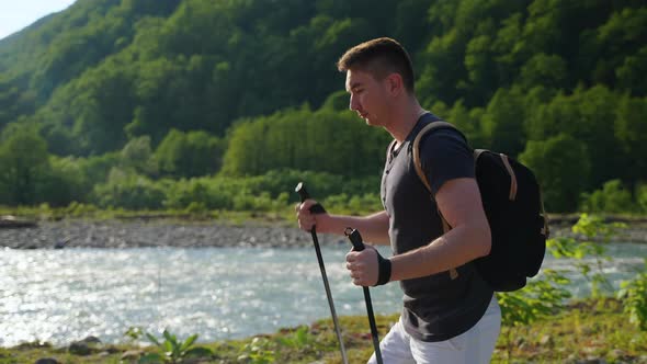 Man Backpacker Hiking Along the Mountain River