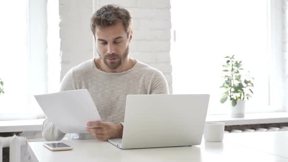 Businessman Reading Documents in Office