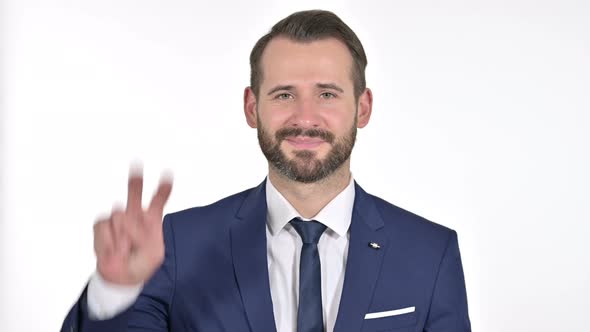 Successful Businessman Showing Victory Sign, White Background