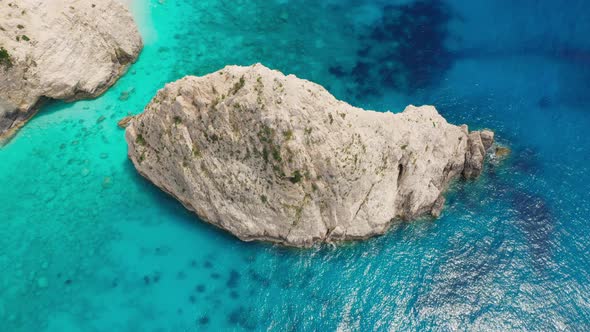 Aerial view of scenic coastline with cliff and aqua blue sea.