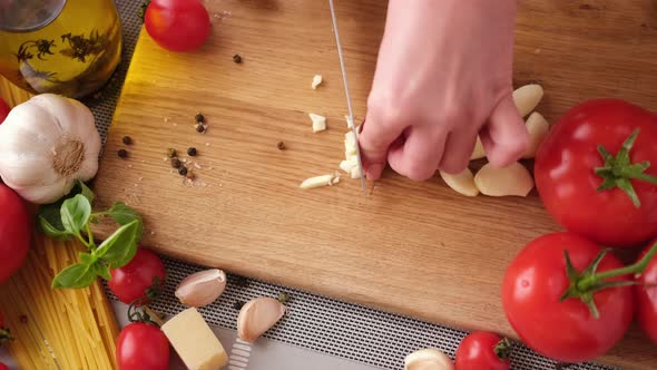 Making Pasta Carbonara  Cut Garlic with Knife on a Wooden Cutting Board