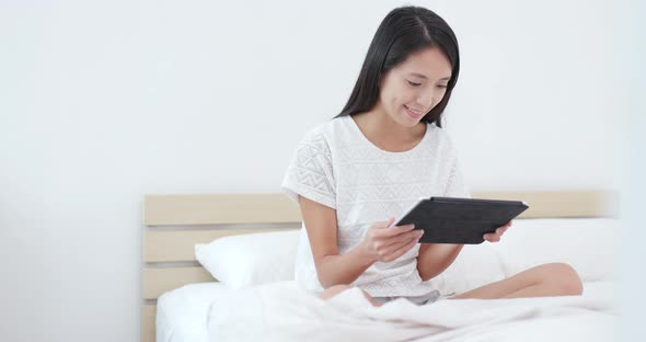 Woman use of tablet on bed