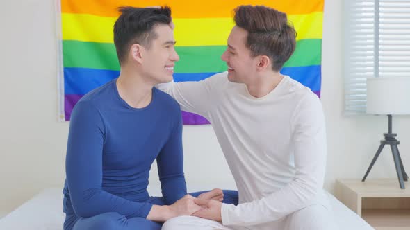 Portrait of Asian handsome man gay family smile and look at each other with rainbow background