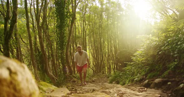 Man Walk Along a Steep Slope Within Dense Forest