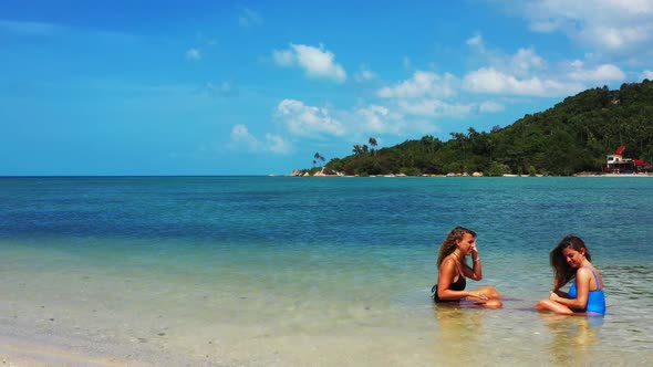 Women tan on tranquil seashore beach trip by blue green lagoon with clean sand background of Koh Pha