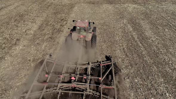 Farmer in Tractor Preparing Land with Seedbed Cultivator