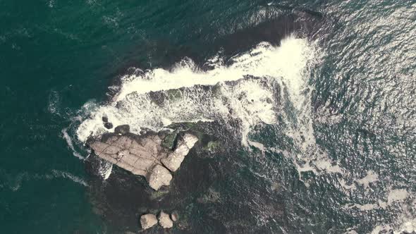 waves crashing cliffs view from drone shot