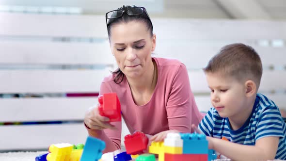 Medium Closeup Happy Adorable Mother Enjoying Playing Game Toys Cubes with Little Cute Son