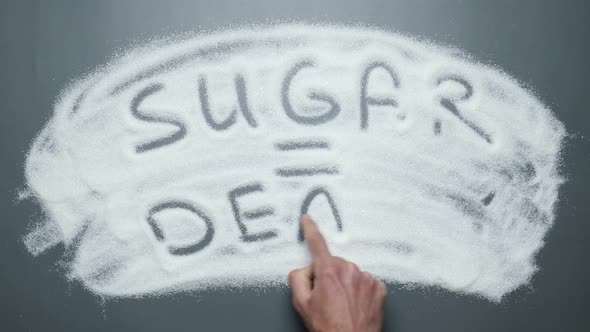 Sugar equals death text written on sugar surface.