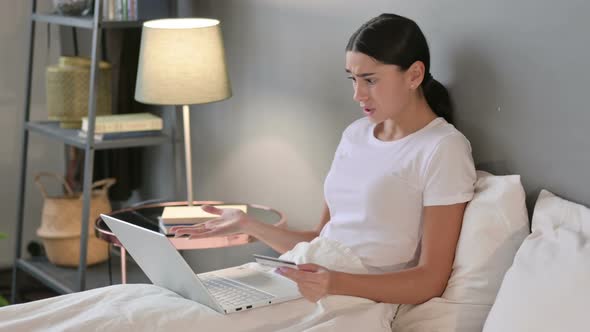 Latin Woman Online Shopping Failure on Laptop in Bed 