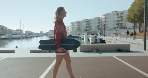 Woman with Skateboard in the Early Morning at Port